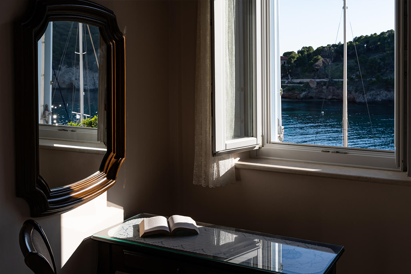 Interior of the Assos View Villas with a window view and a reading table to enjoy seclusion